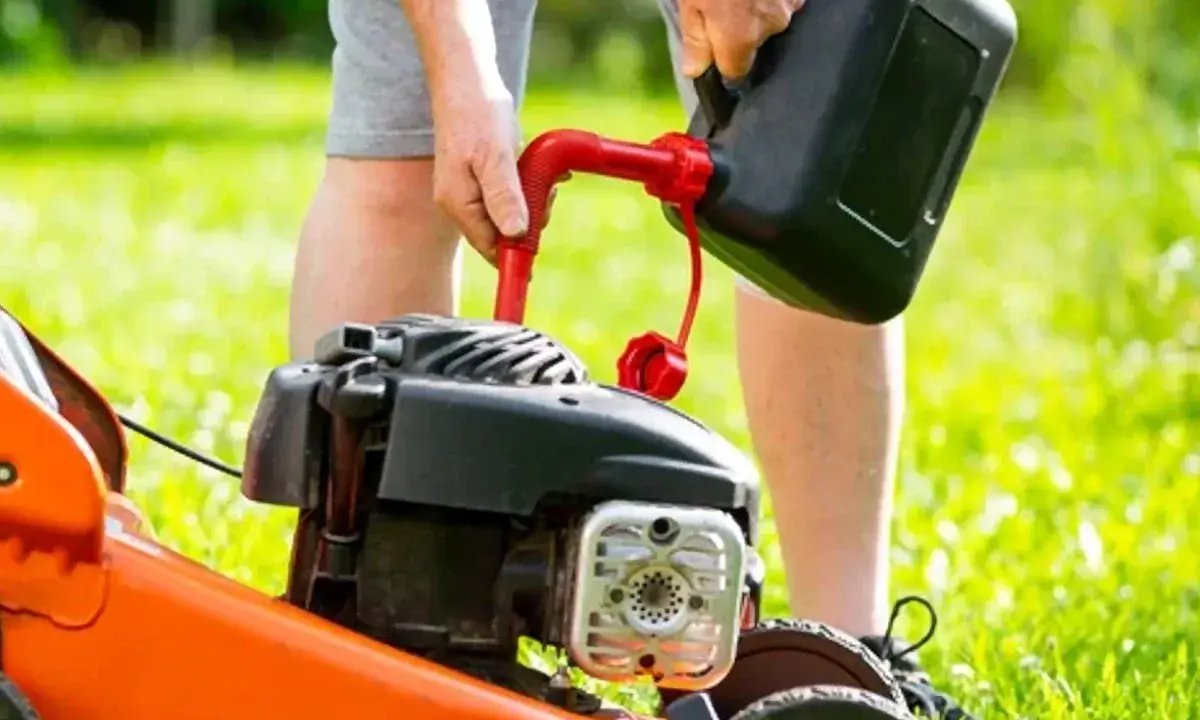 Osoba nalewa paliwo do kosiarki Briggs & Stratton. Użyj benzyny bezołowiowej 95.