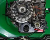Silnik kosiarki Briggs & Stratton z widocznym gaźnikiem i świecą zapłonową. Podpowiadamy, jak ustawić zapłon w kosiarce Briggs & Stratton.