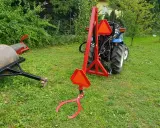 Czerwony podnośnik do traktorka kosiarki, gotowy do pracy. Pokazuje, jak zrobić podnośnik do traktorka kosiarki.