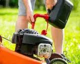 Osoba nalewa paliwo do kosiarki Briggs & Stratton. Użyj benzyny bezołowiowej 95.