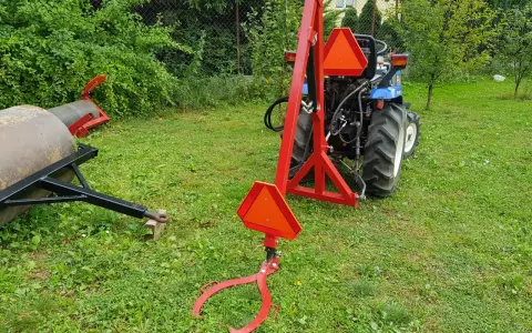 Czerwony podnośnik do traktorka kosiarki, gotowy do pracy. Pokazuje, jak zrobić podnośnik do traktorka kosiarki.