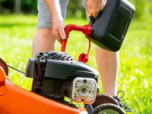 Osoba nalewa paliwo do kosiarki Briggs & Stratton. Użyj benzyny bezołowiowej 95.