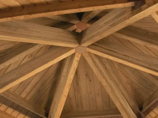 Drewniana konstrukcja dachu altany, idealna jako baza do wyboru, czym przykryć altanę.