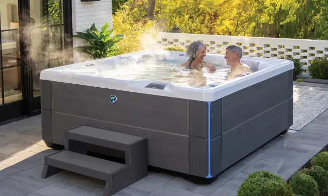 Para relaksu w ogrodzie: para cieszy się kąpielą w jacuzzi. Dowiedz się, jak zabudować jacuzzi ogrodowe, by stworzyć idealne miejsce wypoczynku.