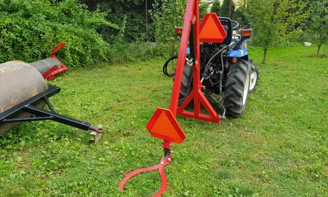 Czerwony podnośnik do traktorka kosiarki, gotowy do pracy. Pokazuje, jak zrobić podnośnik do traktorka kosiarki.